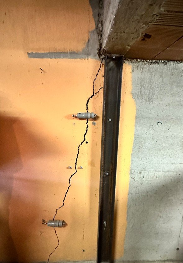 Fissure de mur équipée de deux capteurs de déplacement pour suivre son évolution
