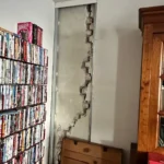 Fissure en escalier dans un mur en briques, enduit déposé pour l'expertise