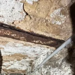 IPN rouillé cave : poutre métallique corrodée au contact d'un mur humide