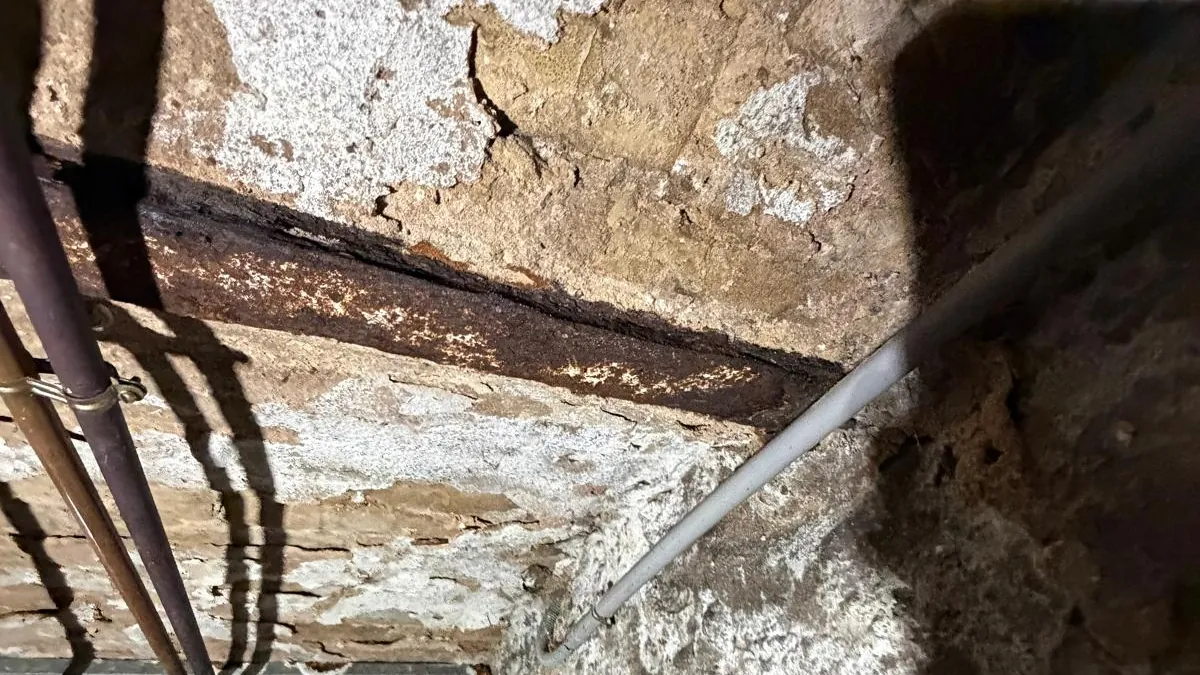 IPN rouillé cave : poutre métallique corrodée au contact d'un mur humide