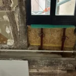 Pan de bois dégradé par une infiltration d'eau, ouvert et étayé dans une cage d'escalier