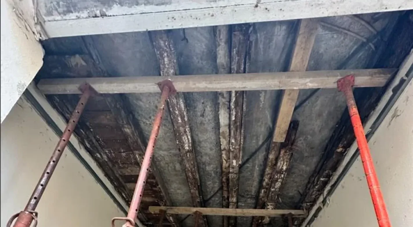 Plancher bois étayé par des étais métalliques dans un immeuble ancien