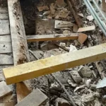 Poutre bois pourrie sous une salle de bain, plancher ouvert avec planches et remplissage