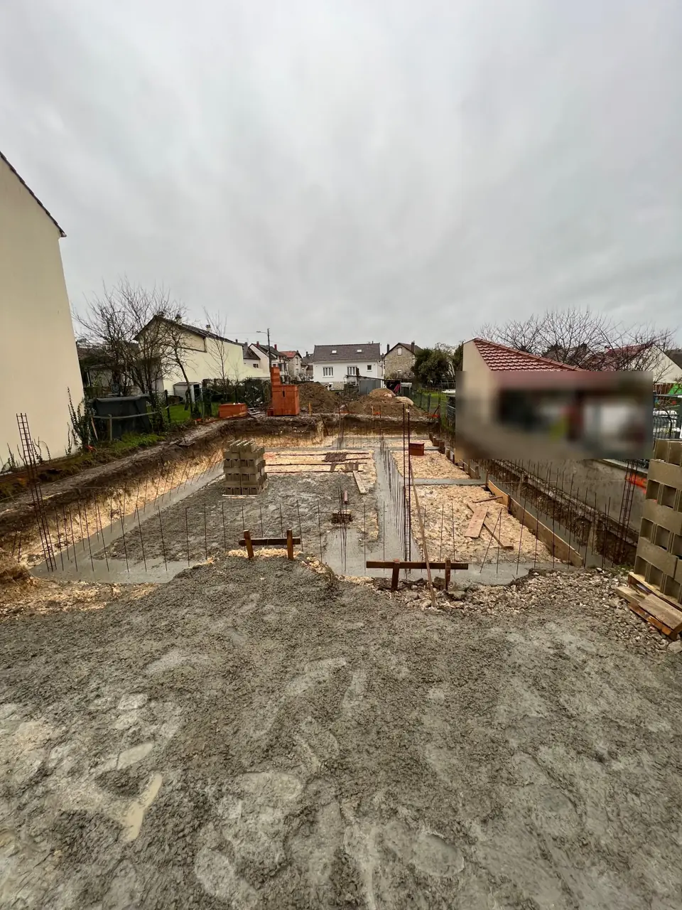 Fondations de maison : semelles filantes en béton coulées, avec les fers en attente pour les murs de soubassement