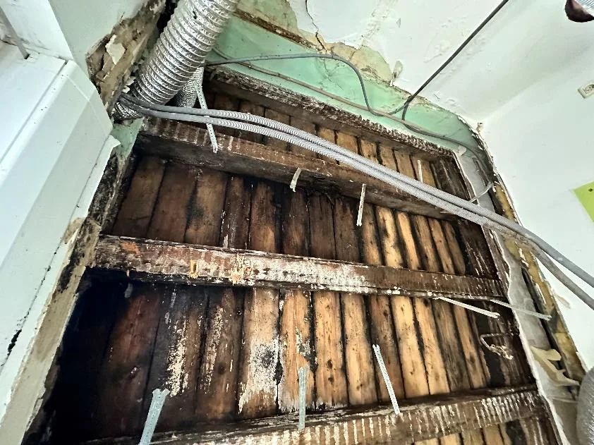 Solives bois dégradées par l'humidité dans un plancher d'immeuble ouvert en sous-face