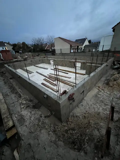 Fondations de maison : soubassement de vide sanitaire en blocs béton terminé, avec fers en attente des chaînages